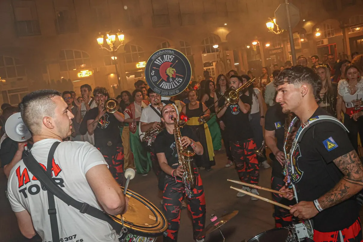 Hijos de Aquiles tocando de noche en una plaza rodeados de público
