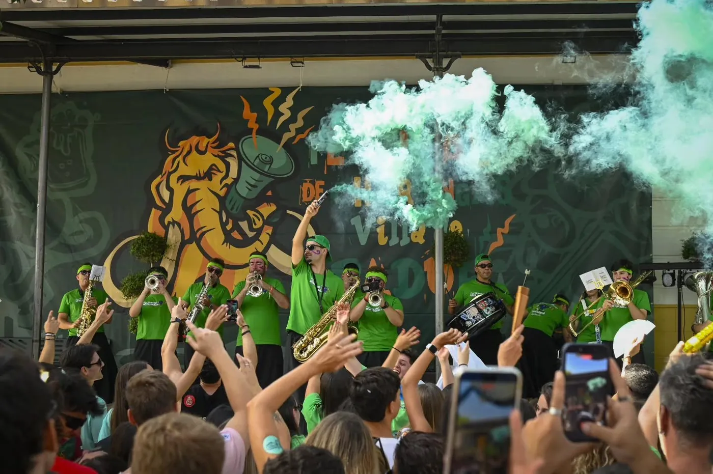 Charanga Nova Jomada actuando en un escenario con humo verde y el público con las manos en alto