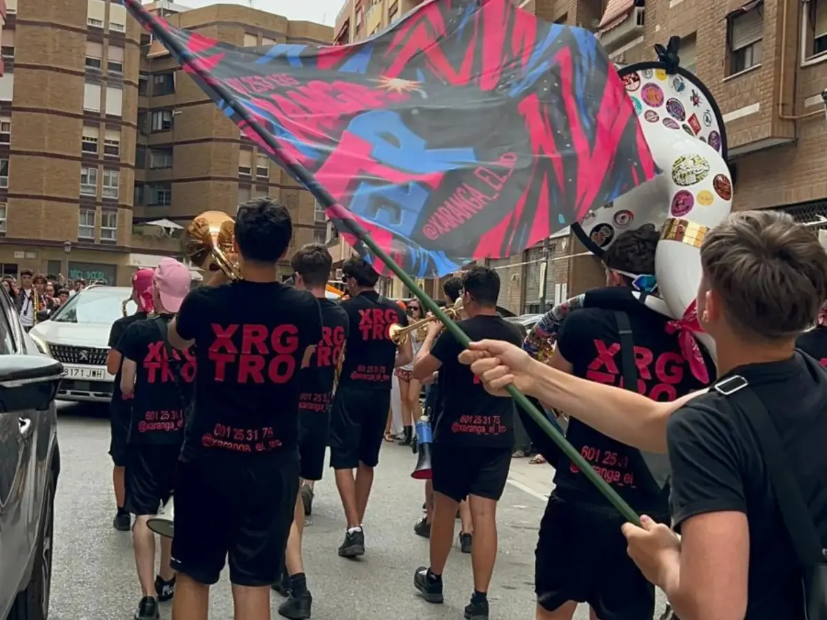 Xaranga El Tro en pasacalles con una bandera grande